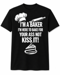 A black short-sleeve crewneck t-shirt with a white graphic print. The design features a chef's hat, a rolling pin, the text 'I'M A BAKER I'M HERE TO BAKE FOR YOUR ASS NOT KISS IT!' in bold white letters, and a slice of layered cake at the bottom.